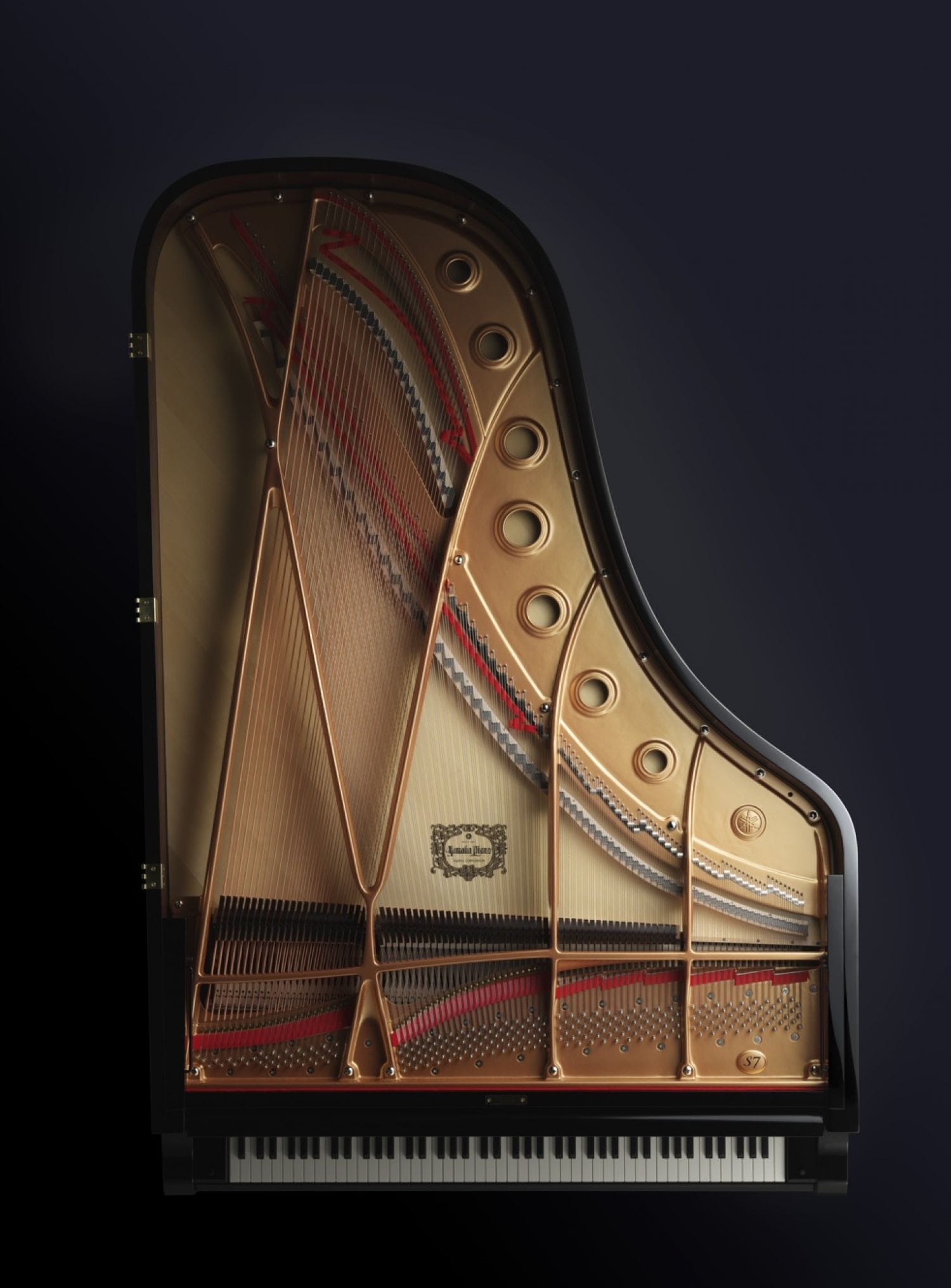 A Yamaha grand piano with lid removed and viewed from above to see entire interior.